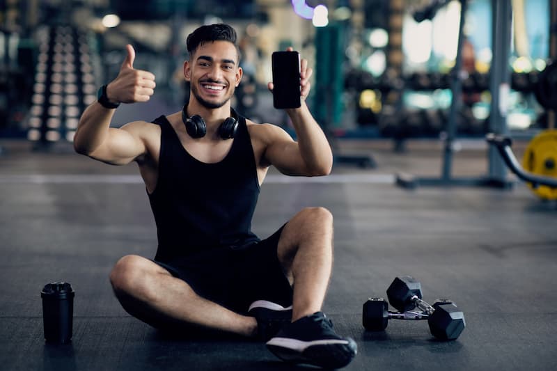 cool-fitness-app-young-arab-man-posing-in-gym-wit